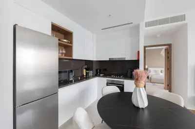 a kitchen with a black table and a refrigerator at Vida Dubai Marina Residences in Dubai