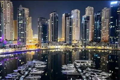 a city at night with boats in the water at Vida Dubai Marina Residences in Dubai