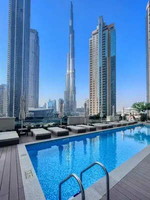 a large swimming pool with a view of the city at Luxurious 2BDR Apartment with Burj Khalifa Views in Dubai