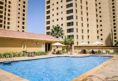 a large swimming pool with two tall buildings at Cozy 2 Bedroom at JBR Beachfront With Pool And Gym in Dubai