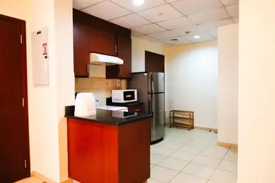 a kitchen with a counter with a microwave and a refrigerator at Cozy 2 Bedroom at JBR Beachfront With Pool And Gym in Dubai
