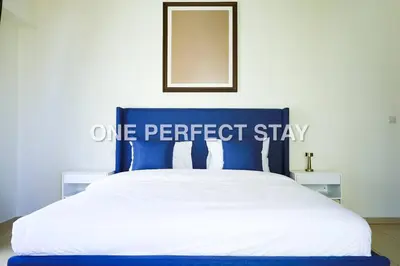 a blue and white bed with a one perfect stay sign on it at Cozy 2 Bedroom at JBR Beachfront With Pool And Gym in Dubai