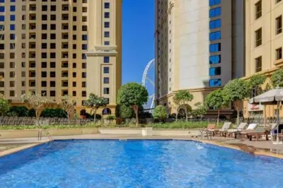 a large swimming pool in a city with buildings at Cozy 2 Bedroom at JBR Beachfront With Pool And Gym in Dubai