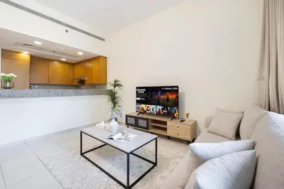 a living room with a couch and a tv at JuliusHomes - Studio in Bay Square, Business Bay Dubai in Dubai
