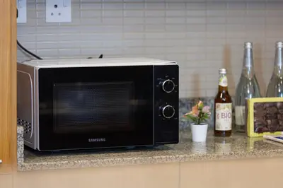 a microwave sitting on a counter in a kitchen at JuliusHomes - Studio in Bay Square, Business Bay Dubai in Dubai
