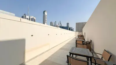 a balcony with tables and chairs on a building at JuliusHomes - Studio in Bay Square, Business Bay Dubai in Dubai