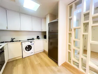 a kitchen with white cabinets and a black refrigerator at Stunning 2BR In Dubai Marina With Amazing views in Dubai