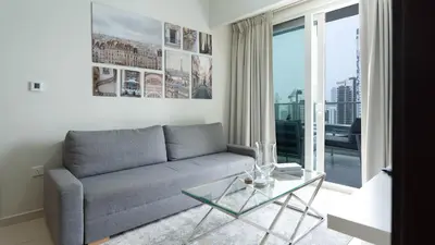 a living room with a couch and a glass table at Luxury 2BR apartment with Burj View GYM & Pool in Dubai