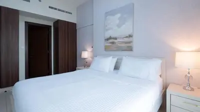 a bedroom with a large white bed with two lamps at Luxury 2BR apartment with Burj View GYM & Pool in Dubai