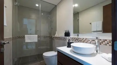 a bathroom with a sink and a shower and a toilet at Luxury 2BR apartment with Burj View GYM & Pool in Dubai