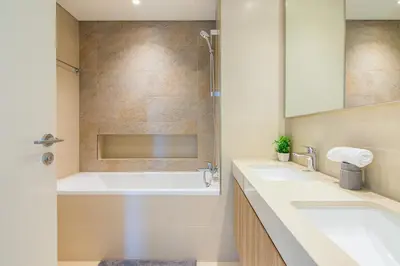 a bathroom with two sinks and a tub at Luxurious 2BR in Downtown Views II, Zaabeel Second in Dubai