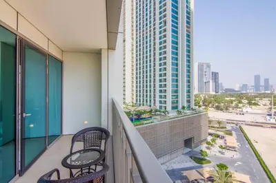 a balcony with two chairs and a view of a city at Luxurious 2BR in Downtown Views II, Zaabeel Second in Dubai