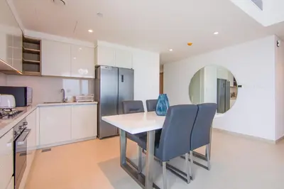 a kitchen with a table and chairs and a refrigerator at Luxurious 2BR in Downtown Views II, Zaabeel Second in Dubai