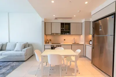 a kitchen and living room with a table and chairs at Luxury Living with Private Beach in Dubai