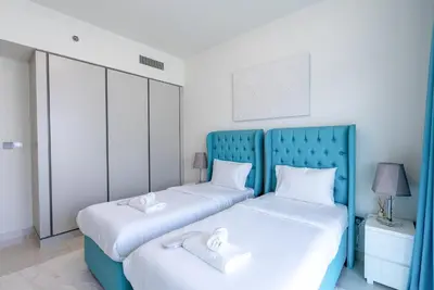 two beds in a bedroom with blue and white at Luxury Living with Private Beach in Dubai