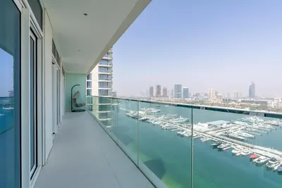 a balcony with a view of a marina with boats at Luxury Living with Private Beach in Dubai