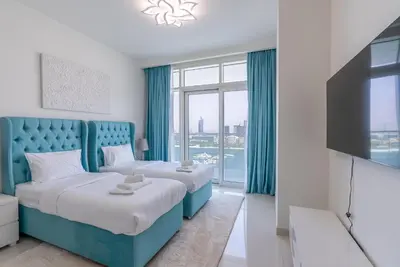 a hotel room with two beds and a flat screen tv at Luxury Living with Private Beach in Dubai