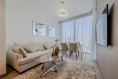 a living room with a couch and a table at Stylish 1 BDR apartment in Sobha Waves in Dubai