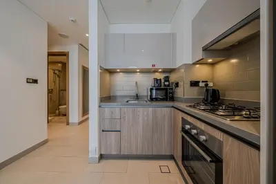 a kitchen with a sink and a stove top oven at Stylish 1 BDR apartment in Sobha Waves in Dubai