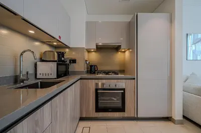 a small kitchen with a sink and a stove at Stylish 1 BDR apartment in Sobha Waves in Dubai
