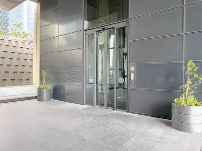 a building with two potted plants in front of it at Blueground DIFC pool gym DXB-468 in Dubai