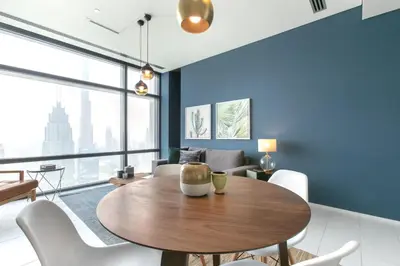 a dining room with a wooden table and white chairs at Blueground DIFC pool gym DXB-468 in Dubai