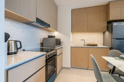 a kitchen with a stove and a microwave at Exquisite 1BDR apartment in Creek with Pool View in Dubai