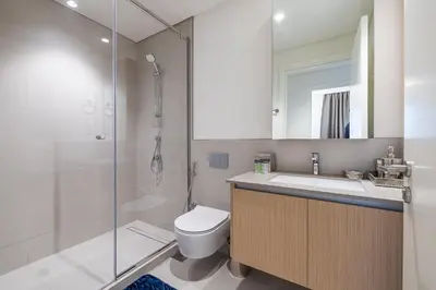 a bathroom with a toilet and a sink and a shower at Exquisite 1BDR apartment in Creek with Pool View in Dubai