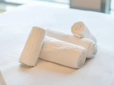 two rolled up towels sitting on a bed at Lavish 2 Bedroom I Burj Khalifa & Fountain Views I Free Gym, Pool, Parking, Wi-Fi and PS5 I by Skyline Serenity in Dubai