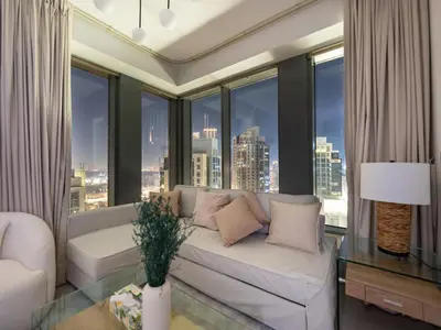 a living room with a couch and large windows at Lavish 2 Bedroom I Burj Khalifa & Fountain Views I Free Gym, Pool, Parking, Wi-Fi and PS5 I by Skyline Serenity in Dubai