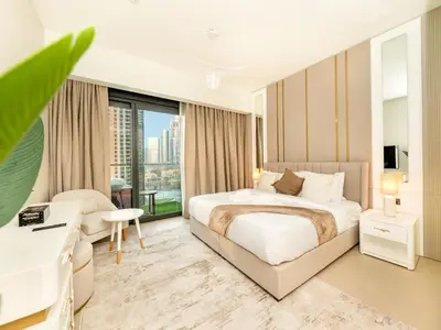 a hotel room with a bed and a desk at Skyline 2 Bedroom Apartment I Burj Khalifa & Fountain Views I Free Gym, Pool, Parking, Wi-Fi and PS5 in Dubai