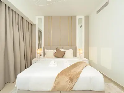 a bedroom with a large white bed with two lamps at Skyline 2 Bedroom Apartment I Burj Khalifa & Fountain Views I Free Gym, Pool, Parking, Wi-Fi and PS5 in Dubai