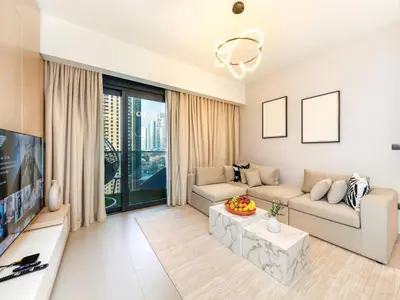 a living room with a couch and a tv at Skyline 2 Bedroom Apartment I Burj Khalifa & Fountain Views I Free Gym, Pool, Parking, Wi-Fi and PS5 in Dubai