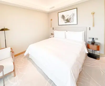 a bedroom with a large white bed and a chair at ADDRESS Residences Opera 2BR Tower 1 - EPIC 30th floor Burj Khalifa view byBLCK with DXB AIRPORT VIP Shuttle option in Dubai