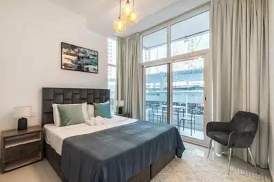 a bedroom with a bed and a chair and a window at ShoresInn - Splendid 1BR in Dubai Marina in Dubai