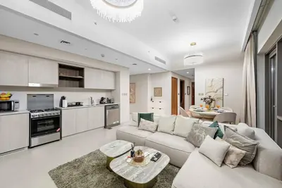 a living room with a couch and a table at Chic 2BR Vida Stay, Creek Views & Prime Location Near Attractions in Dubai