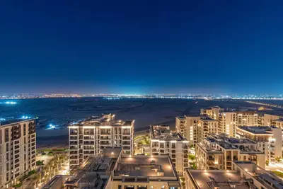 an aerial view of a city at night at Chic 2BR Vida Stay, Creek Views & Prime Location Near Attractions in Dubai