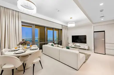 a living room with a couch and a table and chairs at Chic 2BR Vida Stay, Creek Views & Prime Location Near Attractions in Dubai