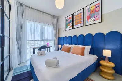 a bedroom with a large bed with a blue headboard at Colorful1BR Apartment in Dubai Hills Next to Mall in Dubai