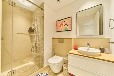a bathroom with a toilet and a sink and a shower at Colorful1BR Apartment in Dubai Hills Next to Mall in Dubai