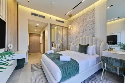 a bedroom with a large white bed and a desk at Bright Studio in Azizi Riviera Perfect Getaway in Dubai
