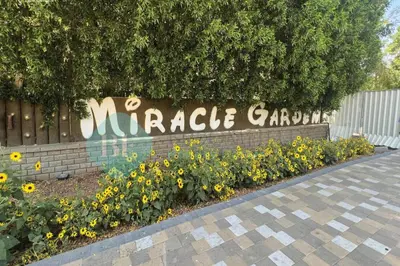 a sign for a miracle garden with yellow flowers at Bloomfields Elegant Stu Jewelz in Dubai