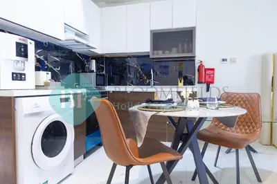 a kitchen with a table and chairs and a washing machine at Bloomfields Elegant Stu Jewelz in Dubai