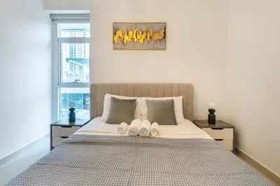 a bedroom with a bed with two slippers on it at ShoresInn - Elite 1BR in Dubai Marina in Dubai