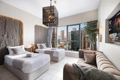 a living room with a couch and a large window at 2BR Steps from JBR Beach in Dubai