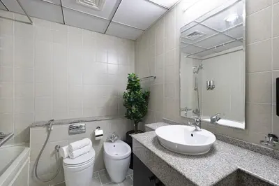 a bathroom with a sink and a toilet and a mirror at 2BR Steps from JBR Beach in Dubai