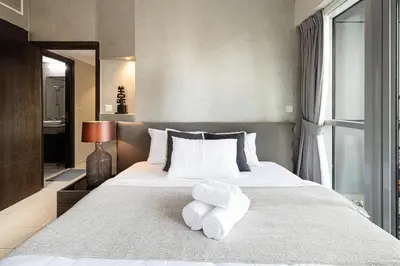 a bedroom with a large bed with towels on it at 2BR Steps from JBR Beach in Dubai