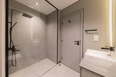 a bathroom with a glass shower and a sink at Brand New Studio 15 mins drive from Business Bay in Dubai