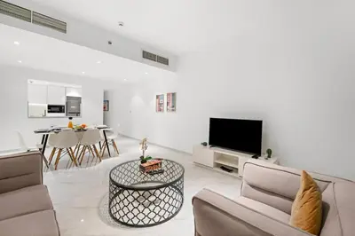 a living room with a couch and a tv and a table at FIRST CLASS 3BR Stylish Sanctuary in Dubai