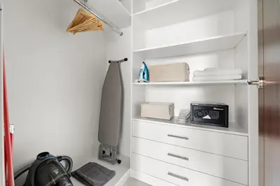 a closet with white drawers and a clock on it at Ace Luxe, 2BR, Downtown, Burj Khalifa & Dubai Fountain view, 5 mins walk to Dubai Mall in Dubai